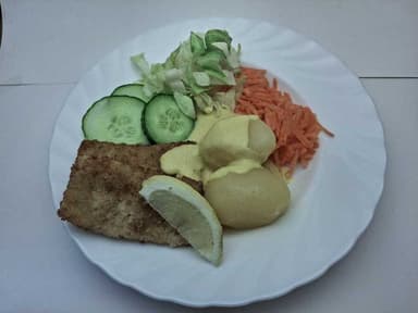 Panerad fisk med potatis, citronsås, citron och måltidstillbehör