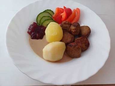 Kycklingköttbullar med kokt potatis och gräddsås samt måltidstillbehör