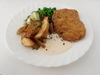 Panerad kycklingbiff med klyftpotatis, mangochutneydressing och måltidstillbehör