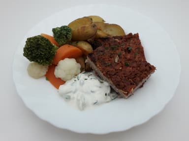 Rutbiff med tomat- och osttäcke serveras med klyftpotatis, tzatziki och måltidstillbehör