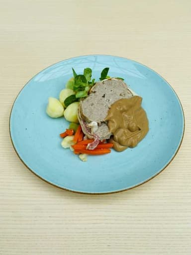 Köttfärslimpa serveras med gräddsås, potatis, grönsak och lingon