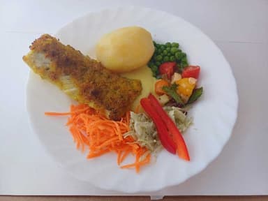 Panerad fisk med potatis, citronsås, citron och måltidstillbehör